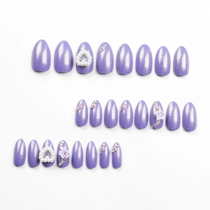Sparkly purple almond press-on nails with white flowers and heart-shaped pearls