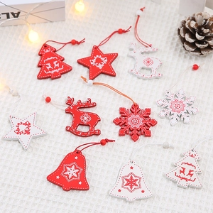 Red and white wooden Christmas ornaments with tree, star, and reindeer shapes on grid background