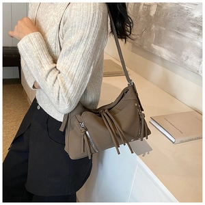 Dettaglio borsa moto kaki in pelle opaca con cerniere a frange lunghe e stile chic