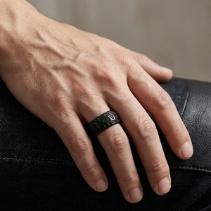 Macro detail of men's matte black stainless steel ring with honeycomb texture etching