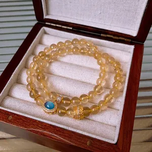 Elegant gold rutilated quartz bracelet set with blue cat-eye stone and hollow metal charm