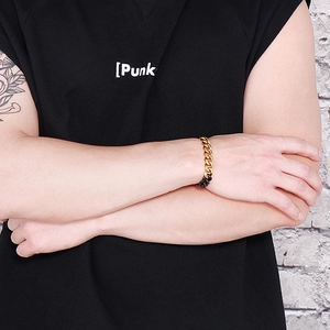 Close-up of punk style thick Cuban link bracelet in gold and black two-tone finish