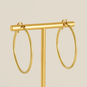 Classic 18K gold plated stainless steel hoop earrings on a golden jewelry display stand