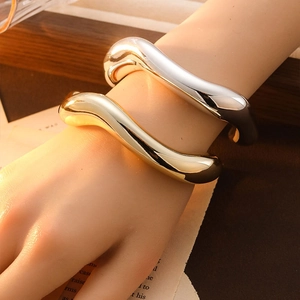 Minimalist wave-shaped open bangles in polished gold and silver finish for women