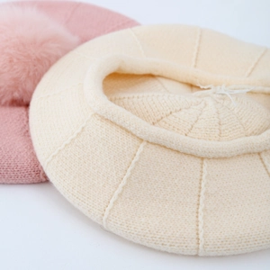 Gros plan sur le béret tricoté avec texture torsadée et pompon doux pour enfants