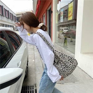 Chic leopard print canvas tote bag with large capacity shown in a lifestyle street view