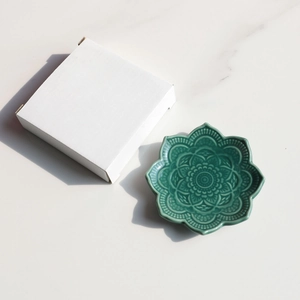 Top view of green ceramic lotus jewelry tray with embossed patterns and white gift box