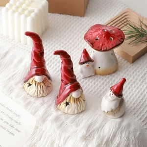 Ceramic Christmas gnome and mushroom figurines on white blanket for winter home decor