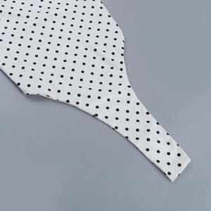 Détail du tissu à pois blancs et noirs du body avec coutures de haute qualité