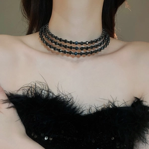 Detailed view of elegant triple-layered black beaded choker on a female model