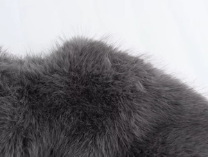 Close-up of high-quality dark gray faux fur texture and soft fluffy fibers on the jacket