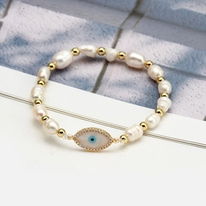 Baroque freshwater pearl bracelet featuring a blue evil eye charm and golden beads