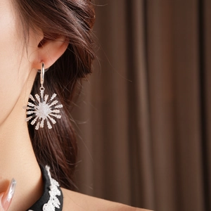 Gros plan de boucles d'oreilles fleurs argentées avec cristaux de zircone brillants