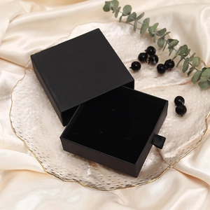 Elegant black drawer jewelry gift box with velvet lining on silk background