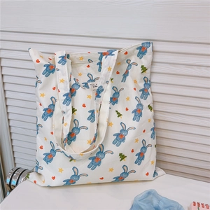 Detail of printed canvas tote bag featuring rabbit patterns and Animal Party inner label