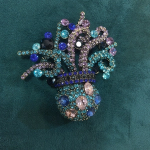 Elaborate octopus brooch with colorful rhinestones on a green velvet background