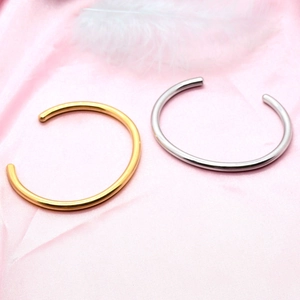 Minimalist 18K gold and silver plated wave pattern open bangles on pink satin