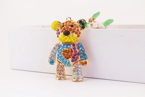 Macro detail of a colorful rhinestone-encrusted bear pendant with gold keychain hardware