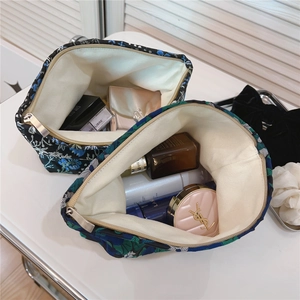 Macro view of blue jacquard makeup bags filled with cosmetics on a white vanity