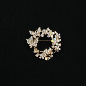 Exquisite golden butterfly wreath brooch with sparkling crystals on a black background