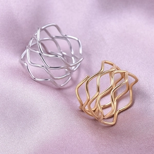 Modern 18K gold and silver plated wave hollow rings on smooth purple silk fabric