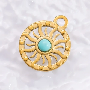 Detailed close-up of 18K gold sunburst pendant with a round turquoise stone inlay