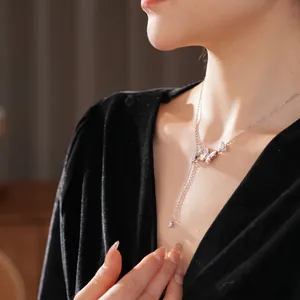 Collier papillon en nacre et zircon avec pampille et pendentif cœur sur le cou