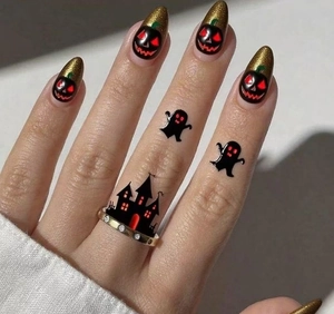 Macro detail of almond press-on nails with golden glitter, Jack-o'-lanterns and haunted house