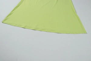 Detail of the grass green dress hem showing high-quality double-needle stitching and fabric
