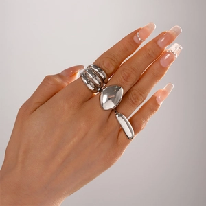 Detailed view of silver liquid metal style rings with unique oval pebble design on hands