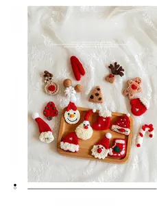 Flat lay of handmade knit Christmas ornaments featuring Santa, snowman, and reindeer
