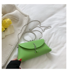 Detail of green jelly bag featuring rhinestone-encrusted ring handle and silver chain strap