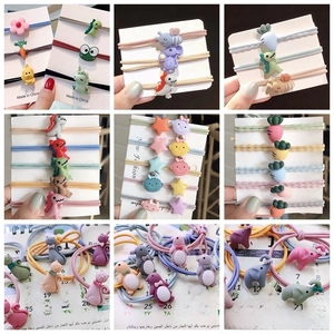 Close-up of colorful resin cartoon hair ties with various animal and fruit shapes