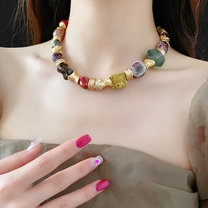 Detail of vintage ceramic floral necklace with colorful beads on a female model