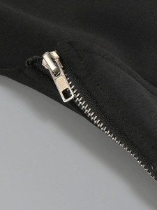Detailed macro view of the silver metal zipper on premium black knitted fabric material