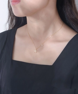 Detail of a gold starfish pendant with sparkling crystals and a pearl on a necklace