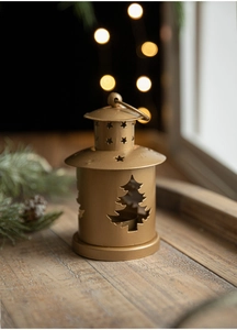 Close-up of golden vintage Christmas candle lantern with festive cutout star patterns
