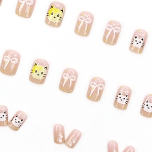 Short press-on nails with pink base, cute cartoon cat, yellow accents, and white bow design