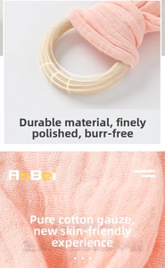 Close-up of pink cotton gauze fabric texture and natural wooden ring for baby comfort