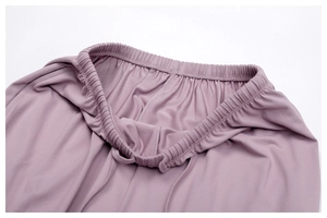 Detailed macro view of the elastic high-waisted gathered band on mauve lounge pants
