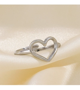 Macro shot of silver hollow heart ring on beige satin featuring adjustable open band