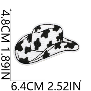 Detailed view of cowboy hat embroidery patch with black and white cow print texture