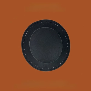 Vista superior de un sombrero de lana negro con costuras decorativas sobre fondo naranja