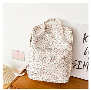 Detail showing the floral backpack front pocket with pink flowers on white canvas