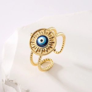 Golden Evil Eye open ring with blue enamel and sunburst pattern on stone background