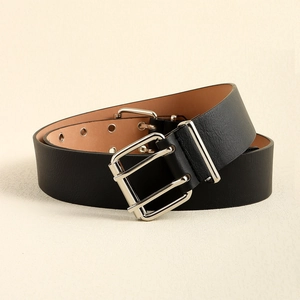 Detail of black leather punk belt featuring double silver buckles and two rows of eyelets