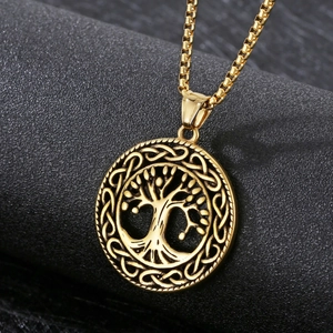 Macro shot of golden Tree of Life pendant and box chain on a dark textured background