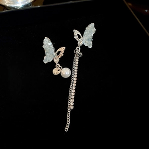 Détail des boucles d'oreilles papillon bleu argenté avec perles et chaînes à franges