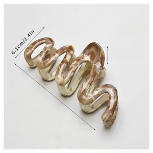 Detailed view of hair claw clip with 13cm size dimensions and brown marble pattern