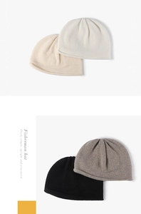 Close-up of knit texture on fisherman hats in beige, black, and grey neutral tones